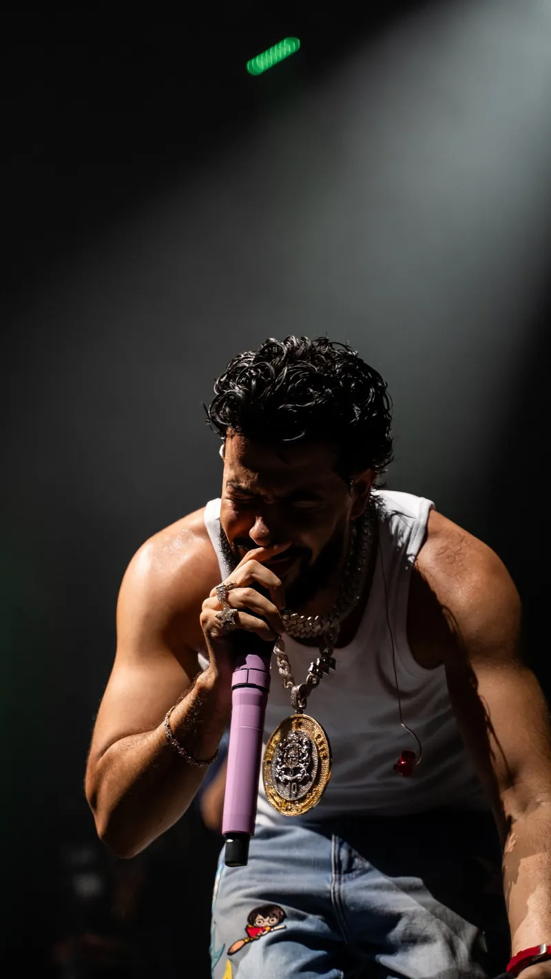 DYSTINCT singing into a pink microphone under a single spotlight