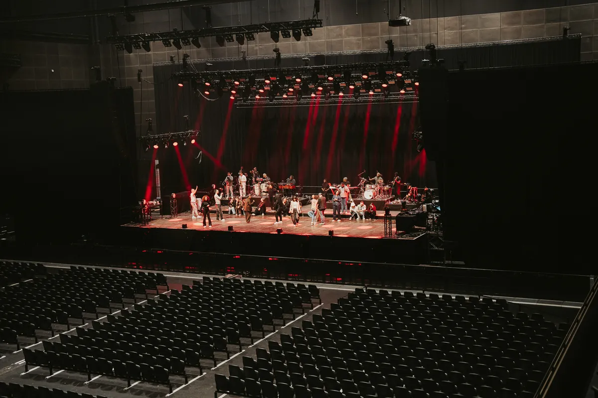 Rehearsal day: ZO! Gospel Choir and band on stage in an empty arena